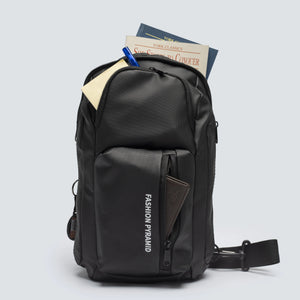 Black backpack with books and a pen on a light gray background
