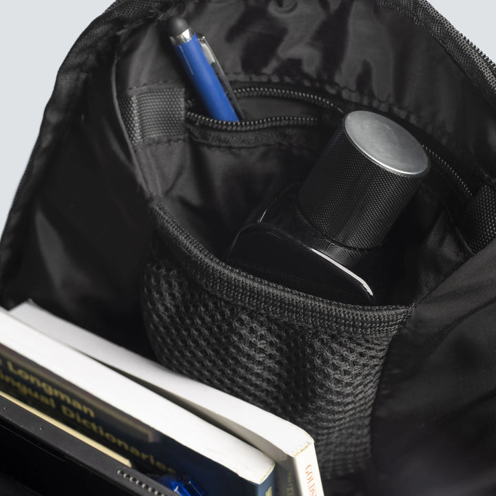 Black backpack with books, a water bottle, and pens inside